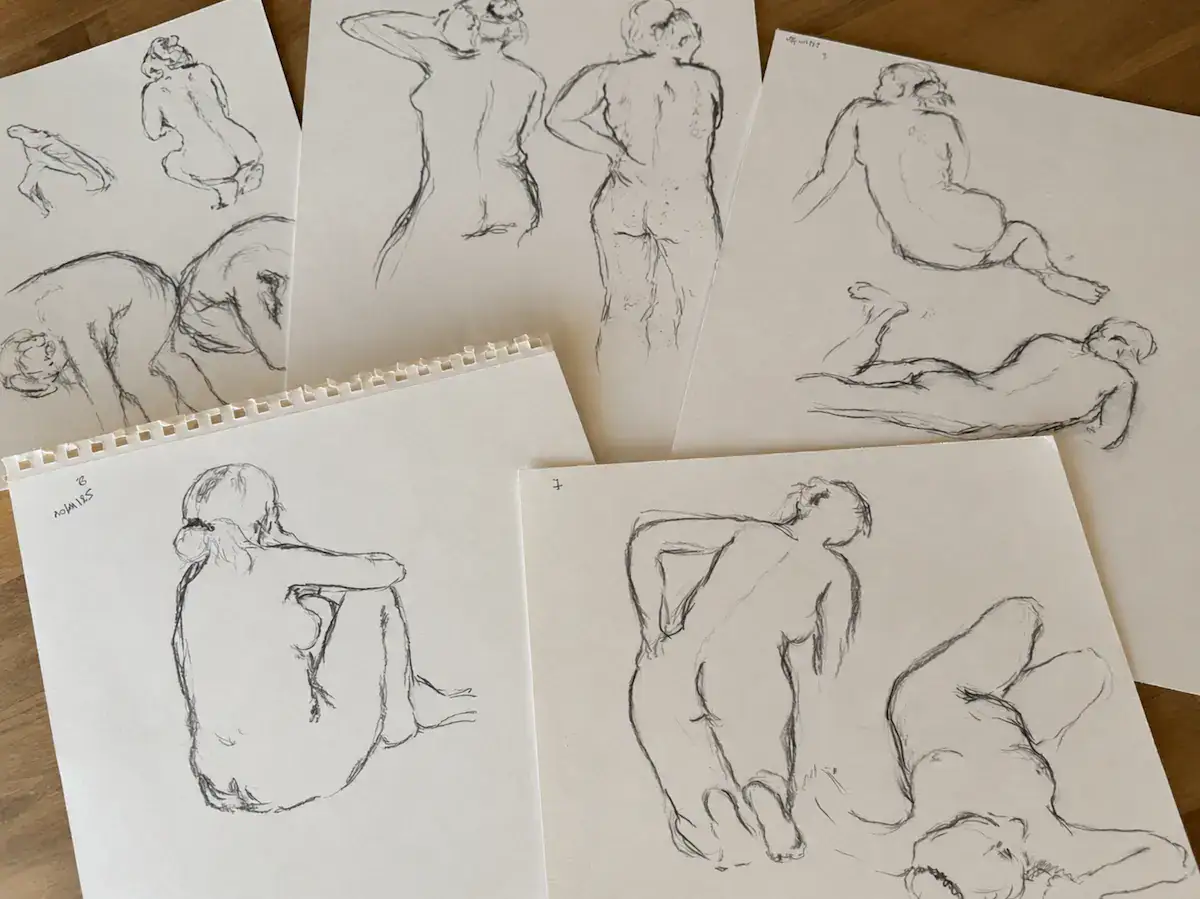 Croquis de nus féminins au fusain, disposés sur une table en bois — Marie-Noëlle Tessier